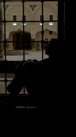 silhouette of woman by window in golden light, love poem and letting go