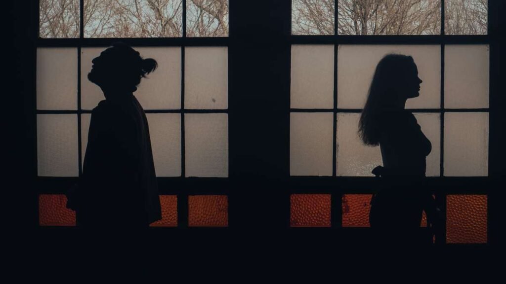 Two silhouettes standing back to back by a window, poem about love illusion and emotional distance