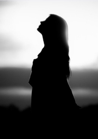 Silhouette of a woman looking up at the sky, a symbol of hope within brokenhearted poems
