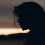 Silhouette of a woman at sunset, symbolizing heartbreak and disbelief in brokenhearted poems